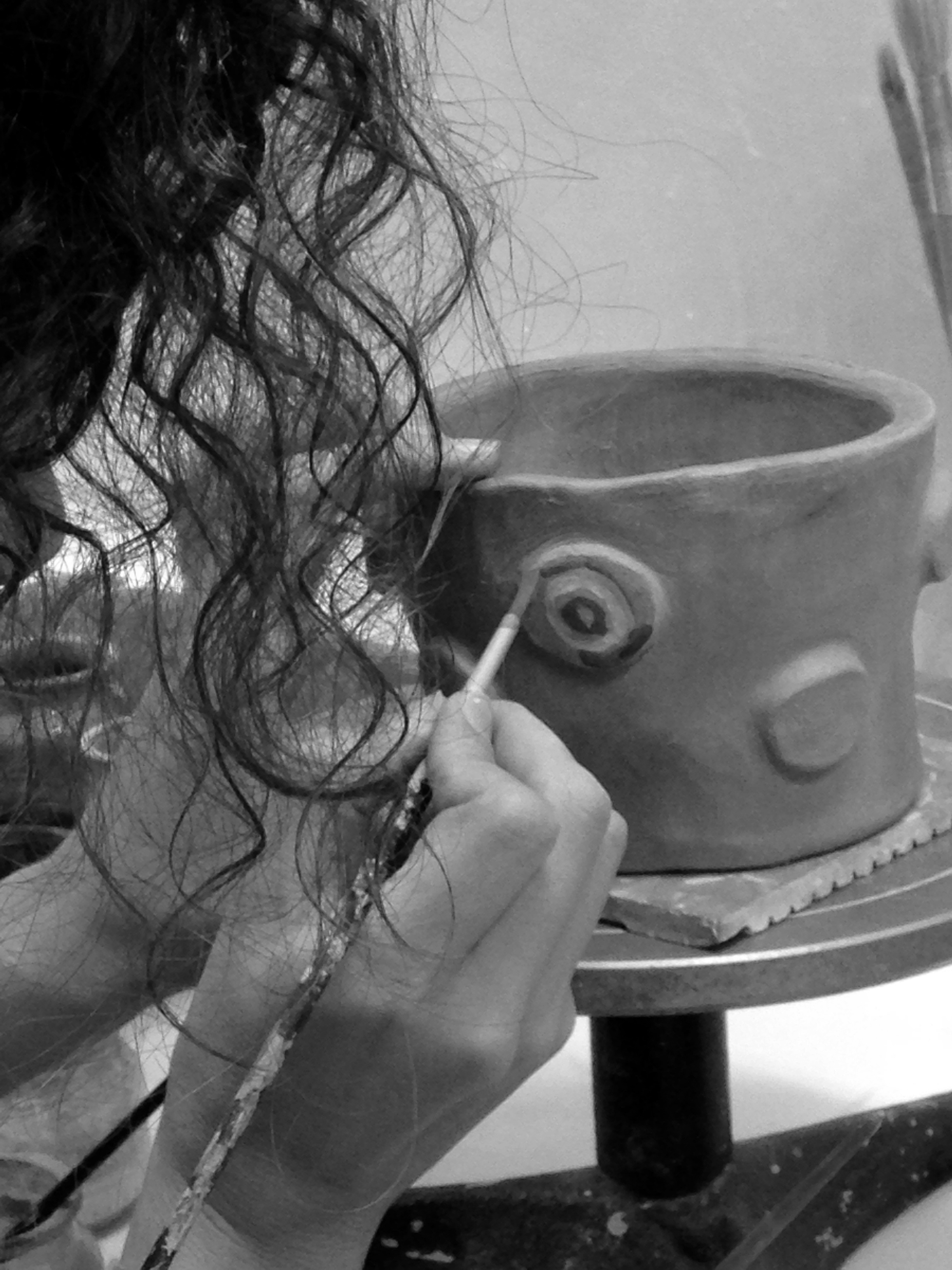 Alumno pintando pieza de cerámica en curso arte-hoy